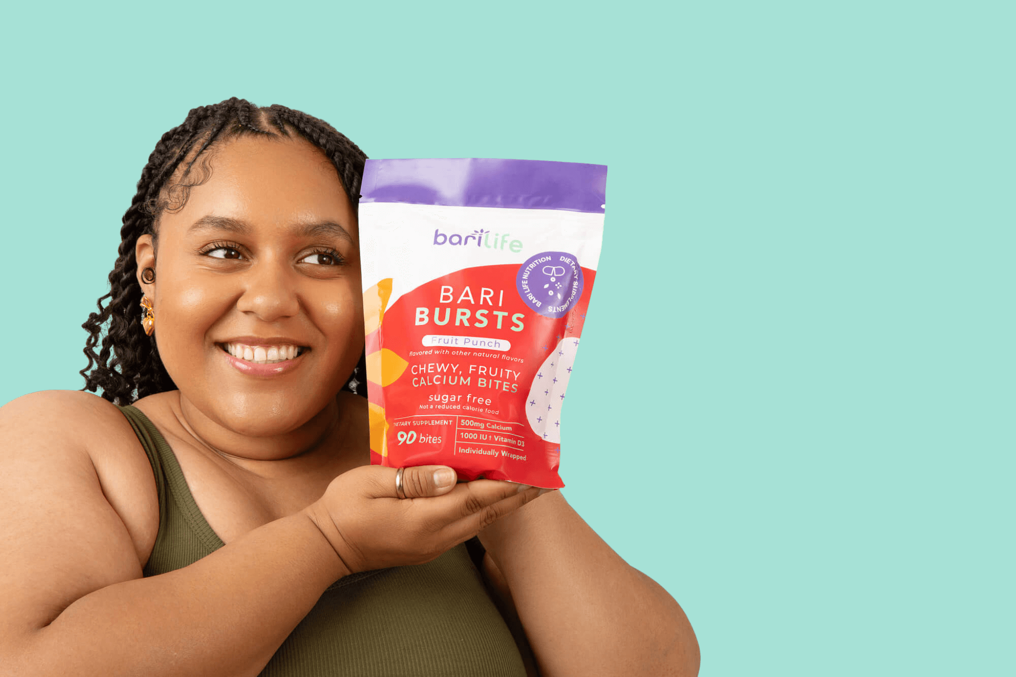 Woman holding Bari Bursts packaging, showcasing chewy fruit calcium bites, sugar-free, from Barilife.